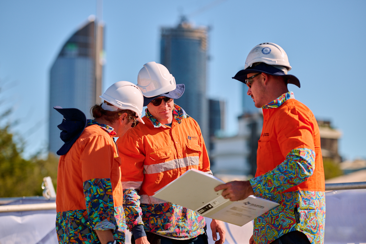 Qualified renewable energy installers from Gardel Electrical & Solar working on the Pineapple Hotel's transition to green energy with Brisbane city in the background